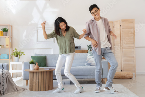 Young Asian friends dancing at home