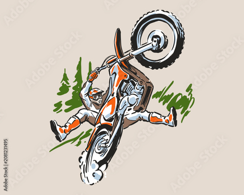 Fotografía Motocross rider performing a daring mid-air wheelie stunt in the forest