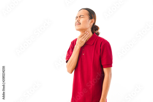 Young Asian male with long hair in a red shirt holding his chest while coughing against a plain white background.