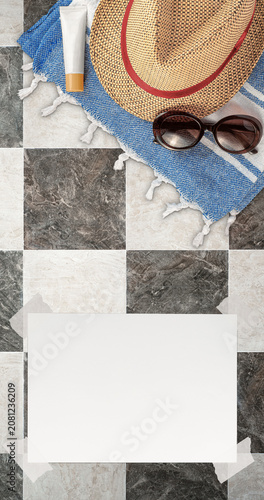 Summer Wallpaper with Straw Hat, Towel, Sunglasses, Protection Cream and White Blank Free Space Paper Sheet with Adhesive Tape on Chequered Stone Tile Surface. File with Clipping Path.