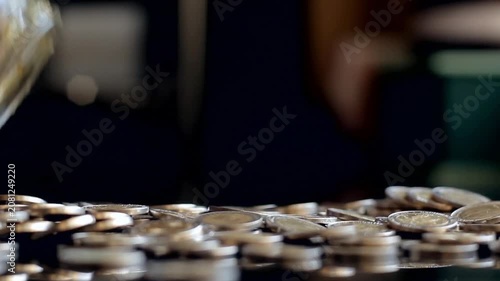 Woman Pouring Argentine Peso Coins From Glass Jar Onto Table And Picking One Up