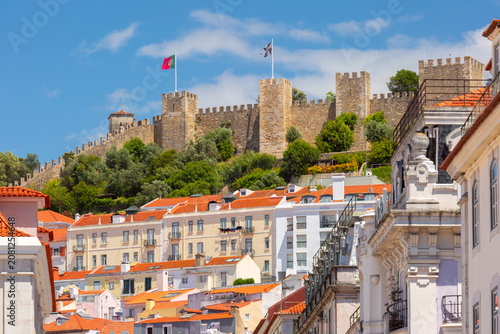 View of Sao Jorge Fortress rising above the historic Alfama district in Lisbon, Portugal.
