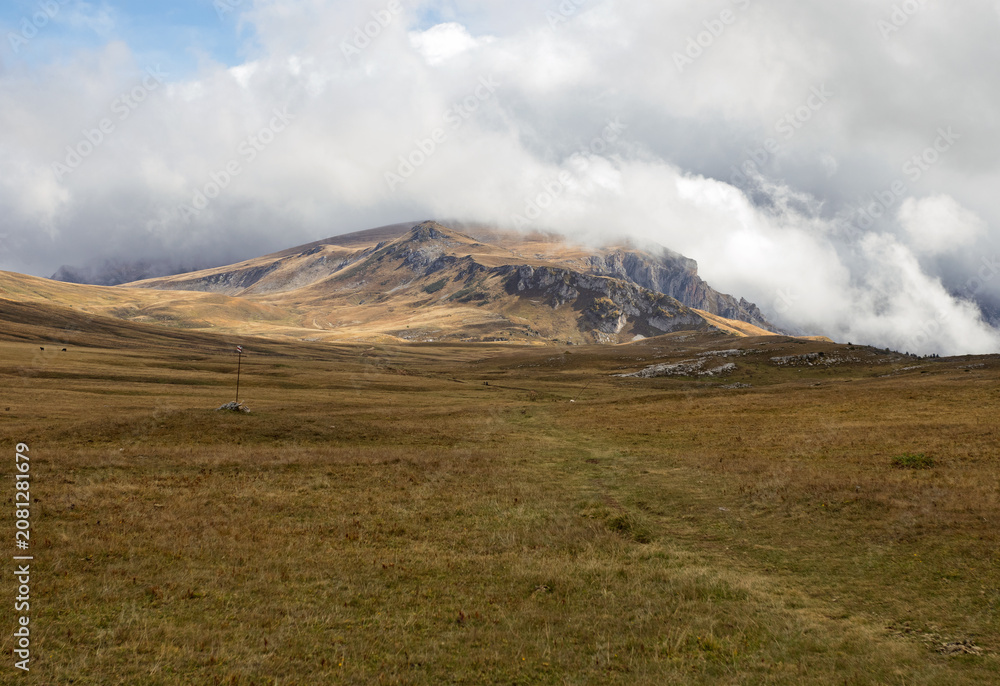 Obraz premium a stone plateau in an alpine area during the autumn season, with dried plants and signs of late autumn