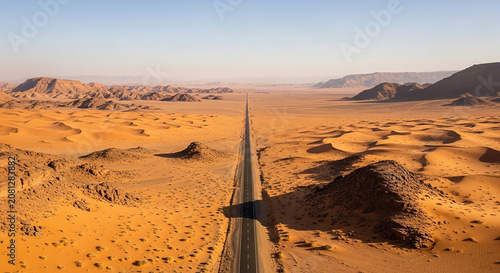 Long empty road passing through a vast dry desert landscape at sunset