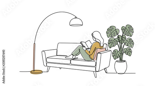 A woman relaxing and reading a book on a comfortable sofa.