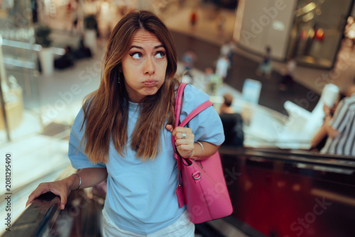 Foto Confused Woman Holding Bag Riding Escalator At Shopping Mall Center