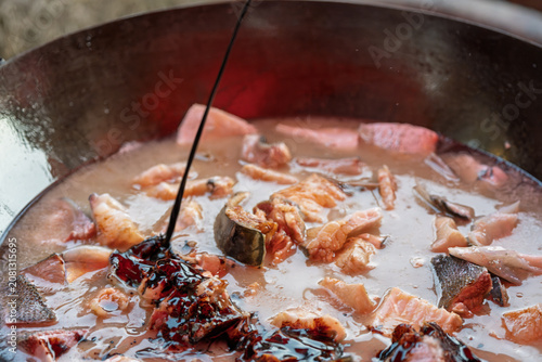 фотографія Fish stewed in iron pot with seasonings cooking process