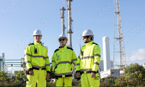 Bild auf Leinwand Engineers in high visibility gear at an oil and gas refinery overseeing operatio