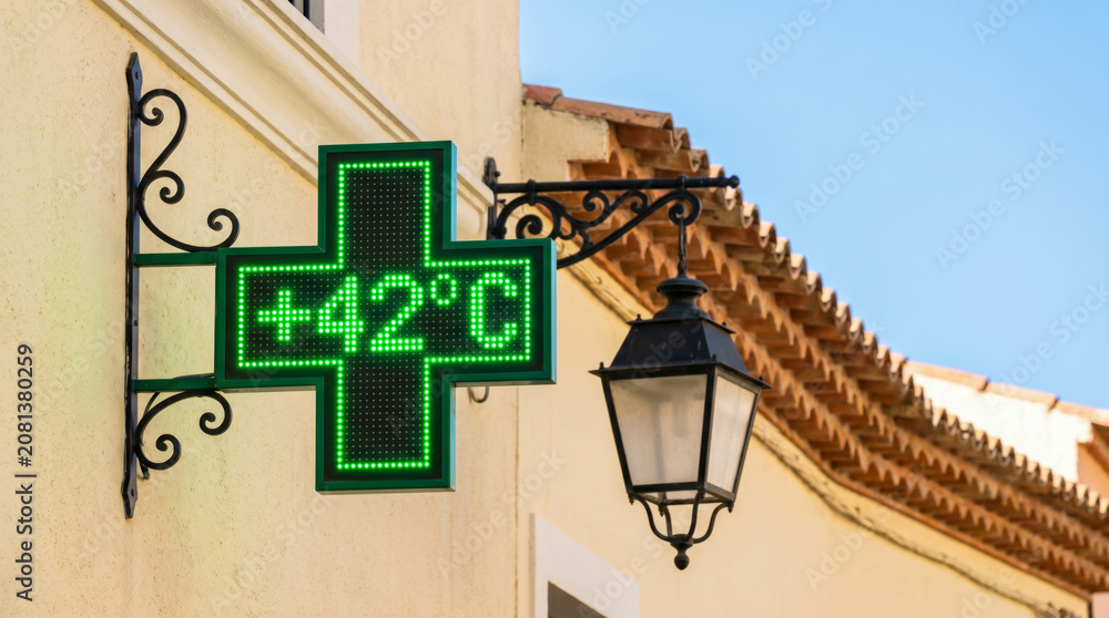 Naklejka premium Heatwave risk climate street pharmacy sign show extreme summer temperature 42 degree digital display. Warming hazard emergency. climate change warning, temperature drought, weather hot summer