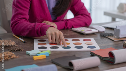 Принти на полотні A close up of a designer's finger touching a blue leather swatch on a color palette board surrounded by fabric rolls and wooden blocks