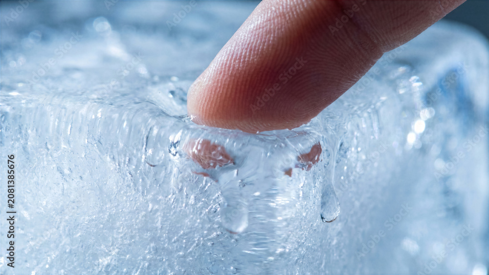 Fototapeta premium Extreme macro shot of hand touching block of solid melting ice clear water drops refraction