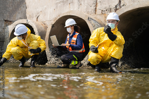 Fotografia Serious team of worker and engineer in yellow protective suit conducting wastewater inspection
