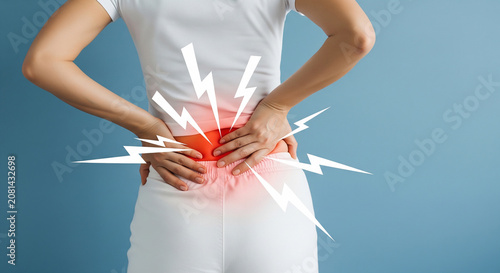 Close up on a person holding their painful lower back, highlighted with a red starburst effect to show acute pain
