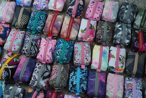 Assorted handmade mini zipper keychain pouches arranged in a flat lay. Collection of fabric zipper pouches displayed as bag accessories and small organizer pouches.
