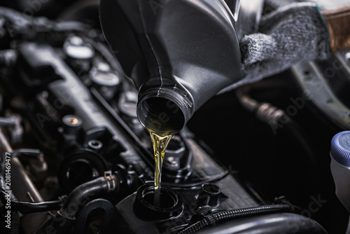  Refueling or changing the engine oil for car maintenance.