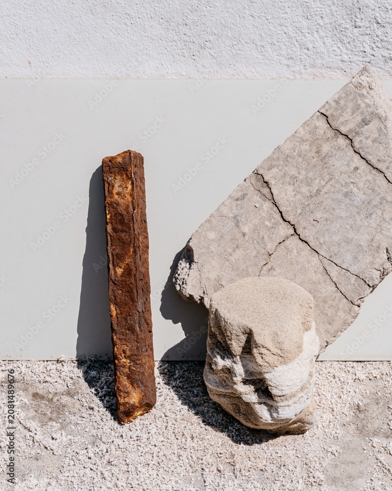 Fototapeta premium Weathered rebar fragment and cracked concrete chip displayed on a light surface for coastal erosion and hurricane damage documentation