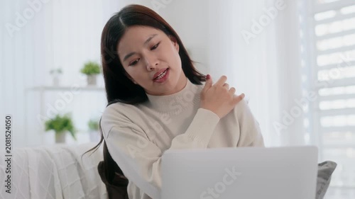 Asian woman using laptop for video conference with doctor at home, telemedicine