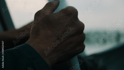 Rugged hand gripping pushbutton control in dim cockpit close-up