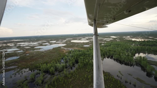 Aerial view of northern wetlands and forest from light aircraft wing