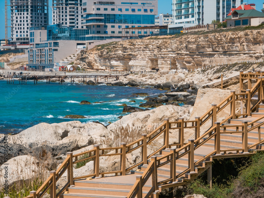 Fototapeta premium Scenic cliffside stairs on Aktau rock trail, Kazakhstan. Coastal boardwalk path near Caspian Sea, epic geological limestone formations