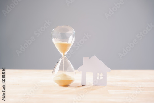 Fotografie Hourglass time house home money mortgage concept, sand flowing, real estate inve