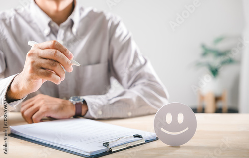 Survey respondent diligently completing customer feedback form expressing satisfaction with service marking positive review offering valuable input for company on clean wooden table