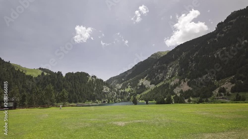 Idyllic summer landscape of the Nuria valley with its reservoir and lush green meadow, a popular destination for leisure and outdoor activities in the Pyrenees mountains of Catalonia, Spain