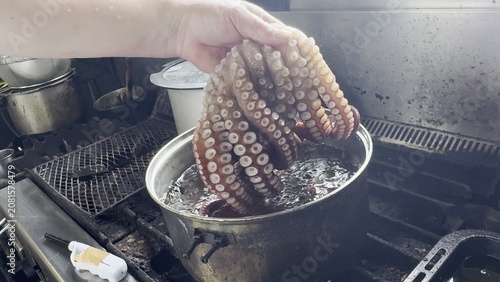 Εκτύπωση καμβά Chef putting a whole fresh octopus into a pot of boiling water at a Japanese iza