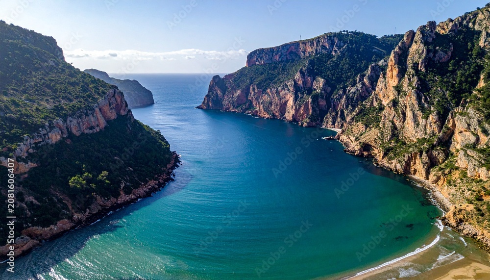 Fototapeta premium Aerial view of a stunning turquoise lagoon surrounded by rocky cliffs.