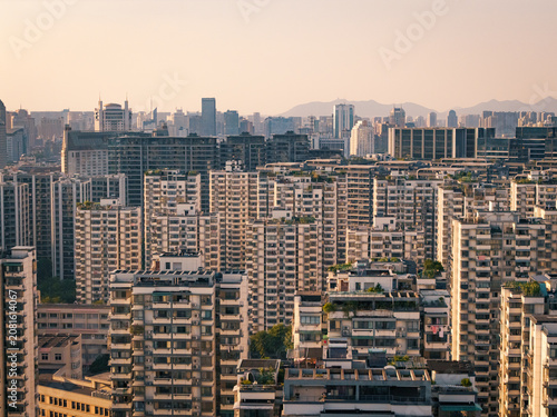 Photos Extensive residential buildings fill a vast urban landscape under warm evening l