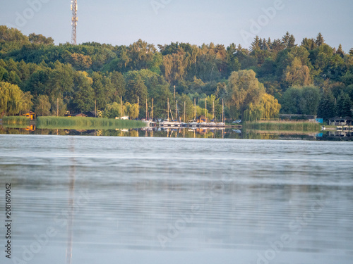 A view of the lake. Sailboats are moored on the far shore.