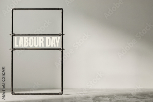 A sturdy industrial pipe structure forms a bold rectangular frame with the significant words LABOUR DAY clearly displayed across its center emphasizing workers' rights