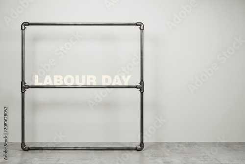 A robust industrial style metal pipe frame structure presenting a minimalist aesthetic with the boldly illuminated words LABOUR DAY clearly displayed within its sturdy geometric confines
