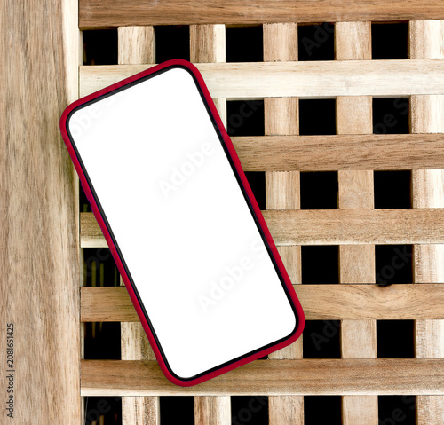 Angled smartphone mockup with green screen on a wooden lattice background. Modern mobile template with copy space for app design and advertising. Blank phone display for branding