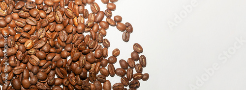 Foto A small group of roasted coffee beans sits in the lower left corner of a white background