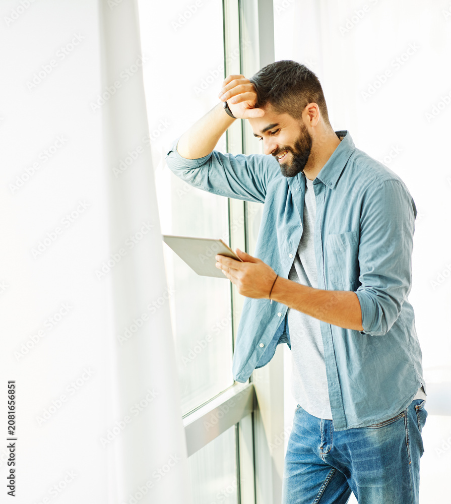 Fototapeta premium Portrait of a young man with a tablet
