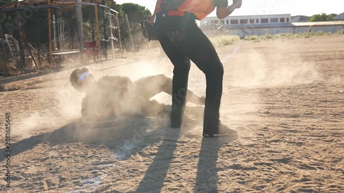 Young baseball player executing a safe slide into base during a competitive game, raising a cloud of dust on the field in slow motion