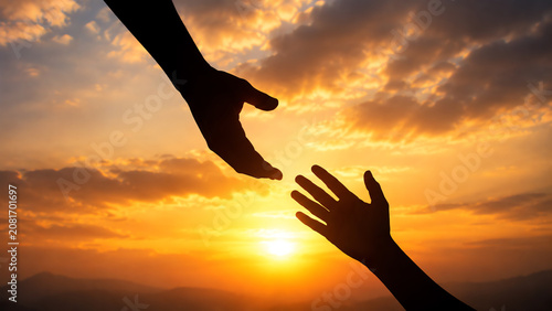 Two hands reaching towards each other at sunset, symbolizing connection, hope, and support in a serene and beautiful setting.
