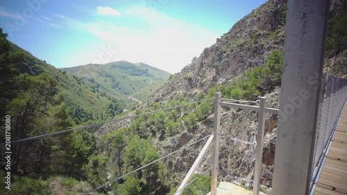 Suspension bridge of 'El Saltillo Canillas de Aceituno' in the beautiful mountain landscape of Canillas de Aceituno on a sunny day, Malaga, Spain