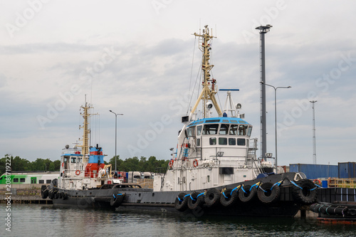 Schilderij op canvas Powerful harbor tugboats moored at industrial port with marine navigation equipm