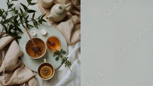 Tea Time With Honey and Herbs on a Table With Candles and Soft Fabric