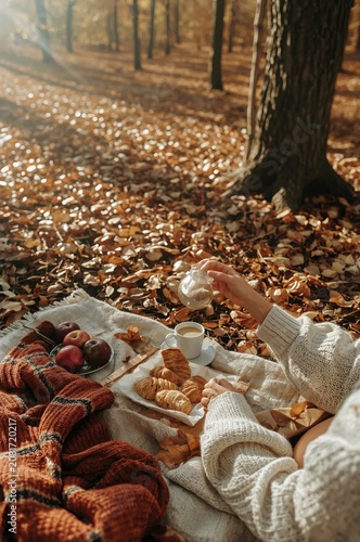Enjoying Coffee and Snacks on a Blanket in a Forest During Autumn
