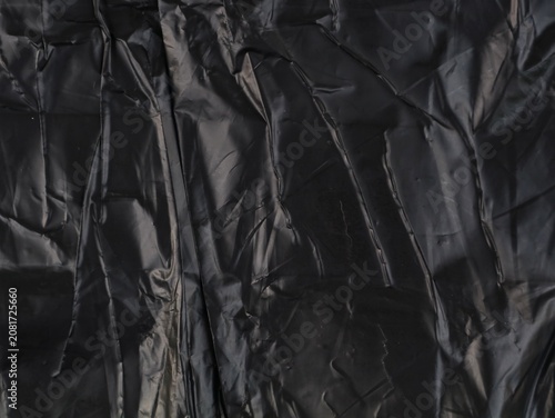 Fotografie Full frame texture background of a heavily crumpled and wrinkled black plastic s
