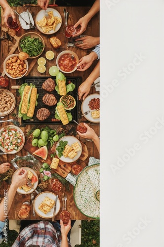 Gathering Around a Table With Food and Drinks During a Summer Day in the Back...