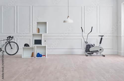 Sport in the room, classic white wall, bike, green gym mat, dumbbell and water style.