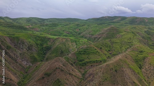 Aerial view Azat Canyon in Armenia. 
Green hills in Armenia near Garni castle.  The landscape features many layers of hills and shadows from clouds above. Nature is present all around with lush greene