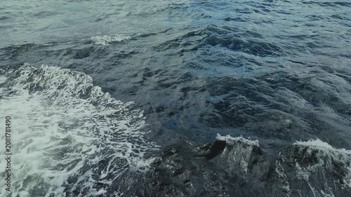 A dynamic sequence showcasing powerful ocean waves crashing against a rocky shoreline, creating a striking visual effect with deep blue water and white foam