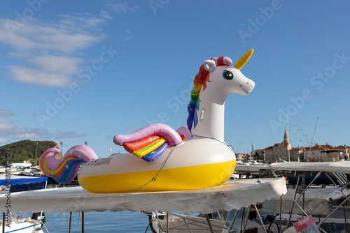 Inflatable unicorn pool toy placed on the roof of a boat in Budva marina, Montenegro