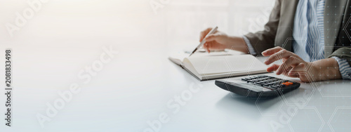 Business professional reviewing financial documents with a calculator, representing budgeting, accounting, financial planning, business analysis, and corporate decision making.