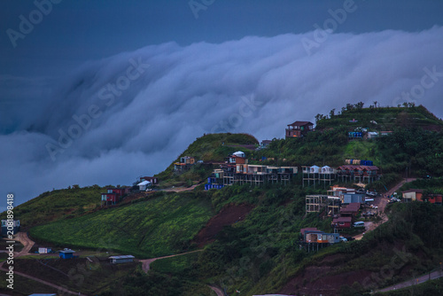 Mist drifts from the mountains above the mountain lodge.